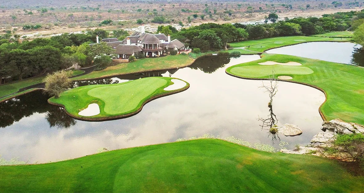 Luftaufnahme des Golfclubs Leopard Creek mit den beiden Greens vor dem Clubhaus.